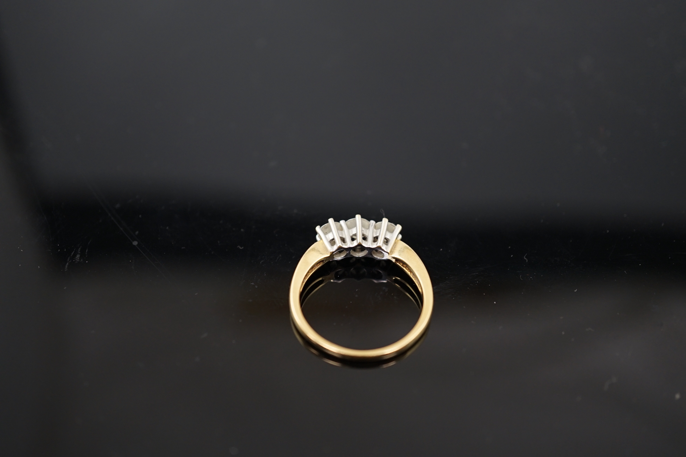 A modern 18ct gold and three stone diamond set ring